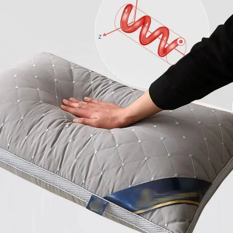 Mano presionando la almohada gris para demostrar la tecnología de soporte activo con rebote, simbolizada por un resorte rojo, indicando alta resiliencia y capacidad anti-colapso