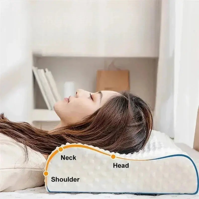Una mujer duerme sobre una almohada cervical blanca de memory foam con puntos de contorno. Una línea gráfica naranja señala los puntos de apoyo ergonómicos para el hombro (Shoulder), el cuello (Neck) y la cabeza (Head), demostrando la alineación correcta de la columna.