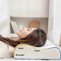 Una mujer duerme sobre una almohada cervical blanca de memory foam con puntos de contorno. Una línea gráfica naranja señala los puntos de apoyo ergonómicos para el hombro (Shoulder), el cuello (Neck) y la cabeza (Head), demostrando la alineación correcta de la columna.