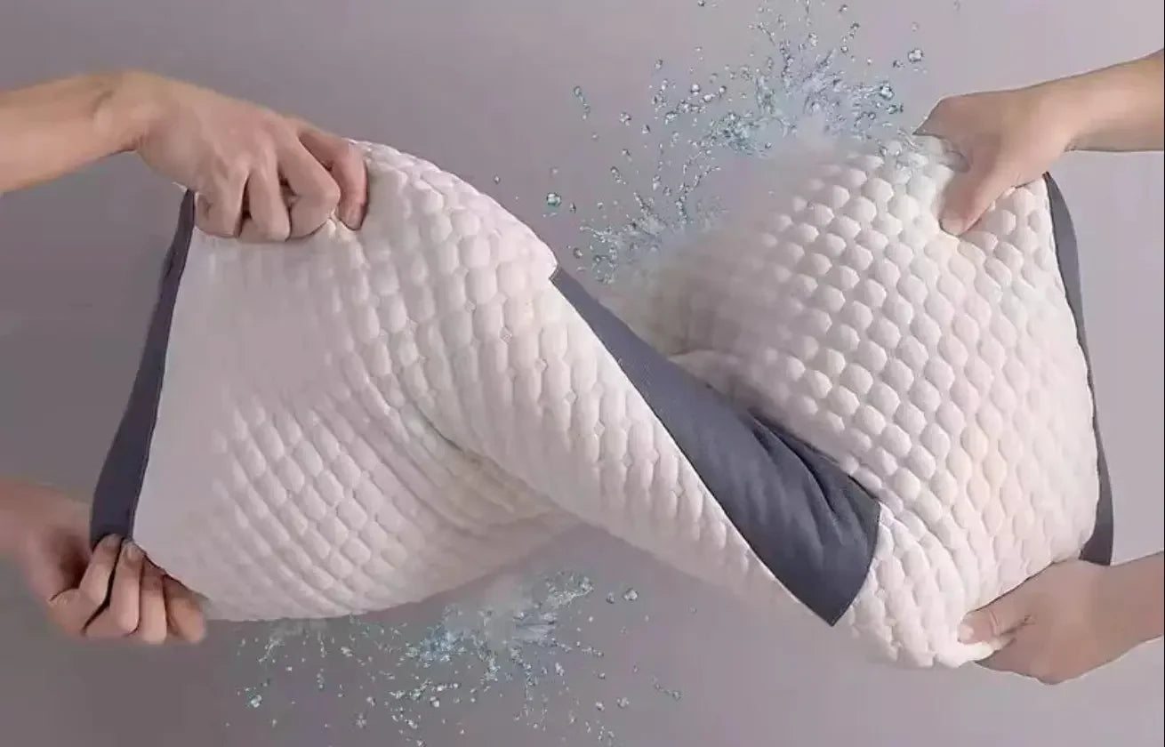 Manos demostrando la alta flexibilidad y suavidad de la espuma viscoelástica de la almohada cervical, con efectos de agua que simbolizan su transpirabilidad y frescura